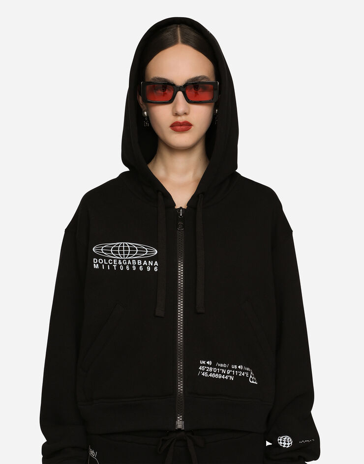 Dolce & Gabbana Kapuzensweatshirt mit langem Arm aus Baumwolljersey mit Print DGVIB3:<br>• Schwarz<br>• Mit Kapuze<br>• Lange Ärmel<br>• Saum und Bündchen im Rippstrick<br>• Paspeltaschen<br>• Normale Passform<br>• Verschluss mit Reißverschluss <br>• Der Artikel hat bei Größe 40 IT eine Länge von 50 cm ab der hinteren Mitte<br>• Das Model ist 175 cm groß und trägt Größe 40 IT<br>• Made in Italy DGVIB3 Schwarz F9R43TG7K6X