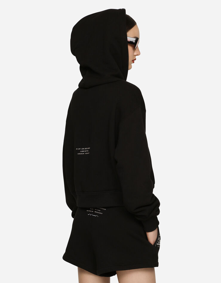 Dolce & Gabbana Kapuzensweatshirt mit langem Arm aus Baumwolljersey mit Print DGVIB3:<br>• Schwarz<br>• Mit Kapuze<br>• Lange Ärmel<br>• Saum und Bündchen im Rippstrick<br>• Paspeltaschen<br>• Normale Passform<br>• Verschluss mit Reißverschluss <br>• Der Artikel hat bei Größe 40 IT eine Länge von 50 cm ab der hinteren Mitte<br>• Das Model ist 175 cm groß und trägt Größe 40 IT<br>• Made in Italy DGVIB3 Schwarz F9R43TG7K6X