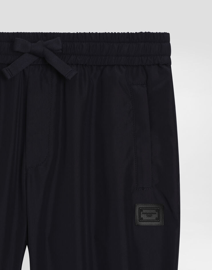 Dolce & Gabbana Pantaloni jogging in nylon con placca logata Blu L44P87FUS0L